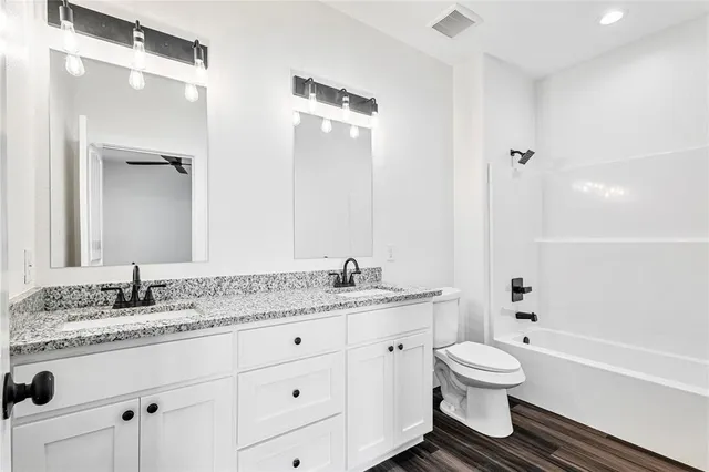 a bathroom with a granite countertop sink toilet and shower