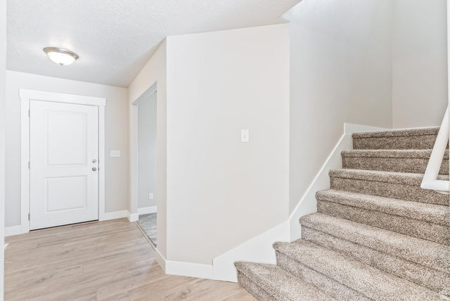 257 North Slant Road, Unit 51M Mapleton, UT 84660 - Photo 2 of 24 Stairway featuring wood finished floors and a textured ceiling