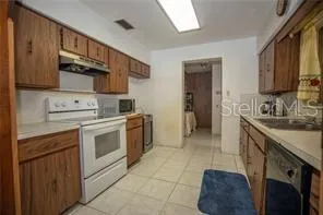 a kitchen with a stove sink and cabinets