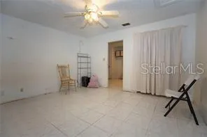 an empty room with windows and a ceiling fan