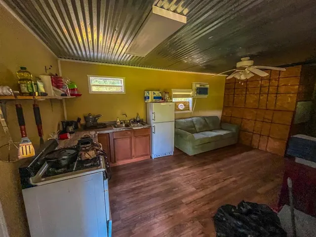 a kitchen with sink a refrigerator and chairs
