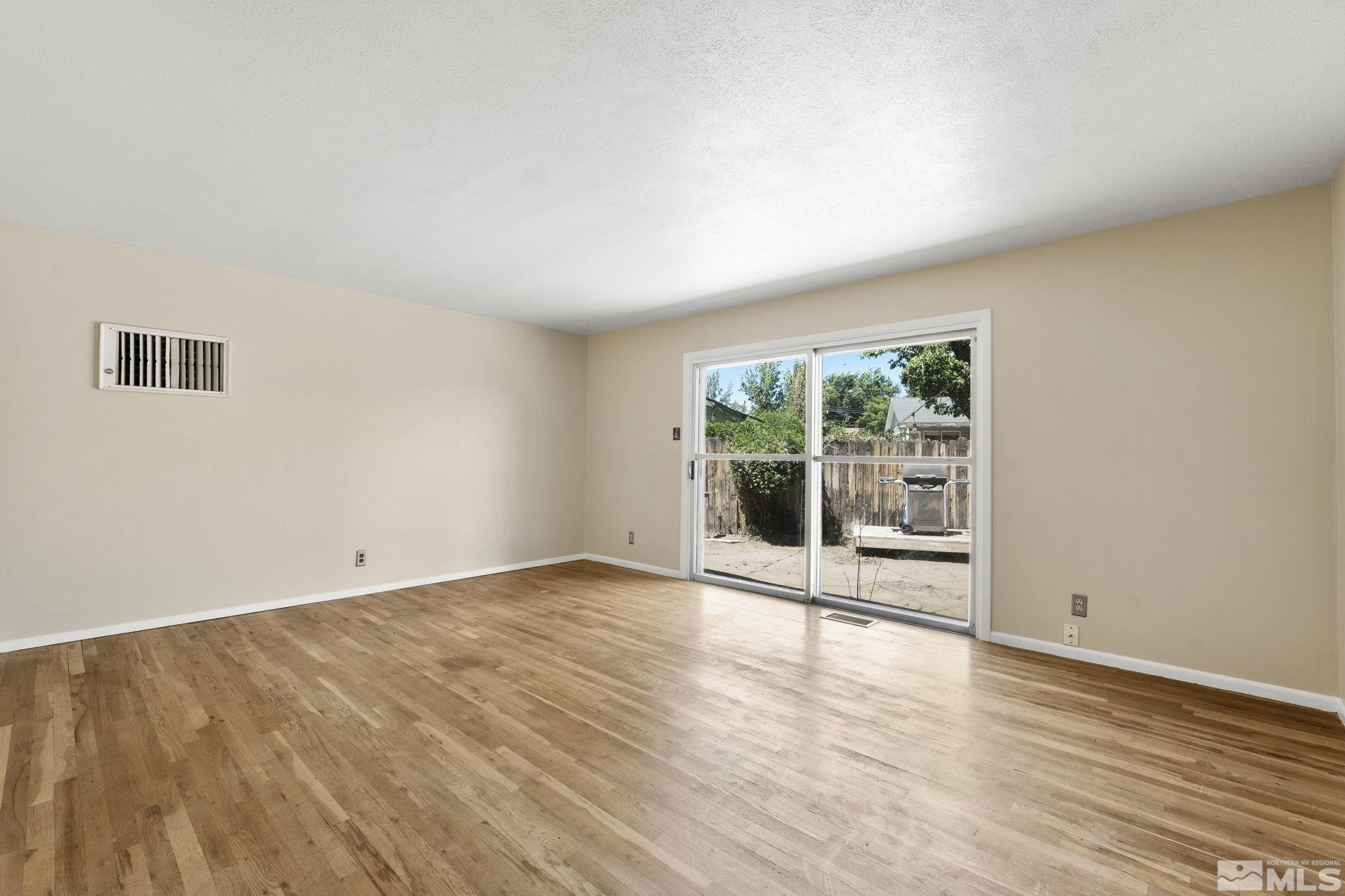 3475 Greta Place Reno, NV 89503 - Photo 3 of 36 a view of an empty room with wooden floor and a window