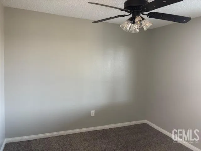 an empty room with a chandelier fan
