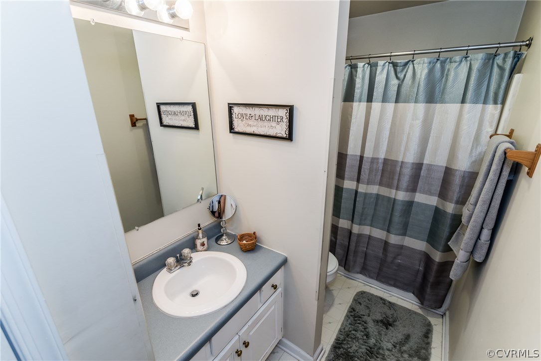17445 Loving Union Road Disputanta, VA 23842 - Photo 28 of 50 a bathroom with a sink and mirror with toilet