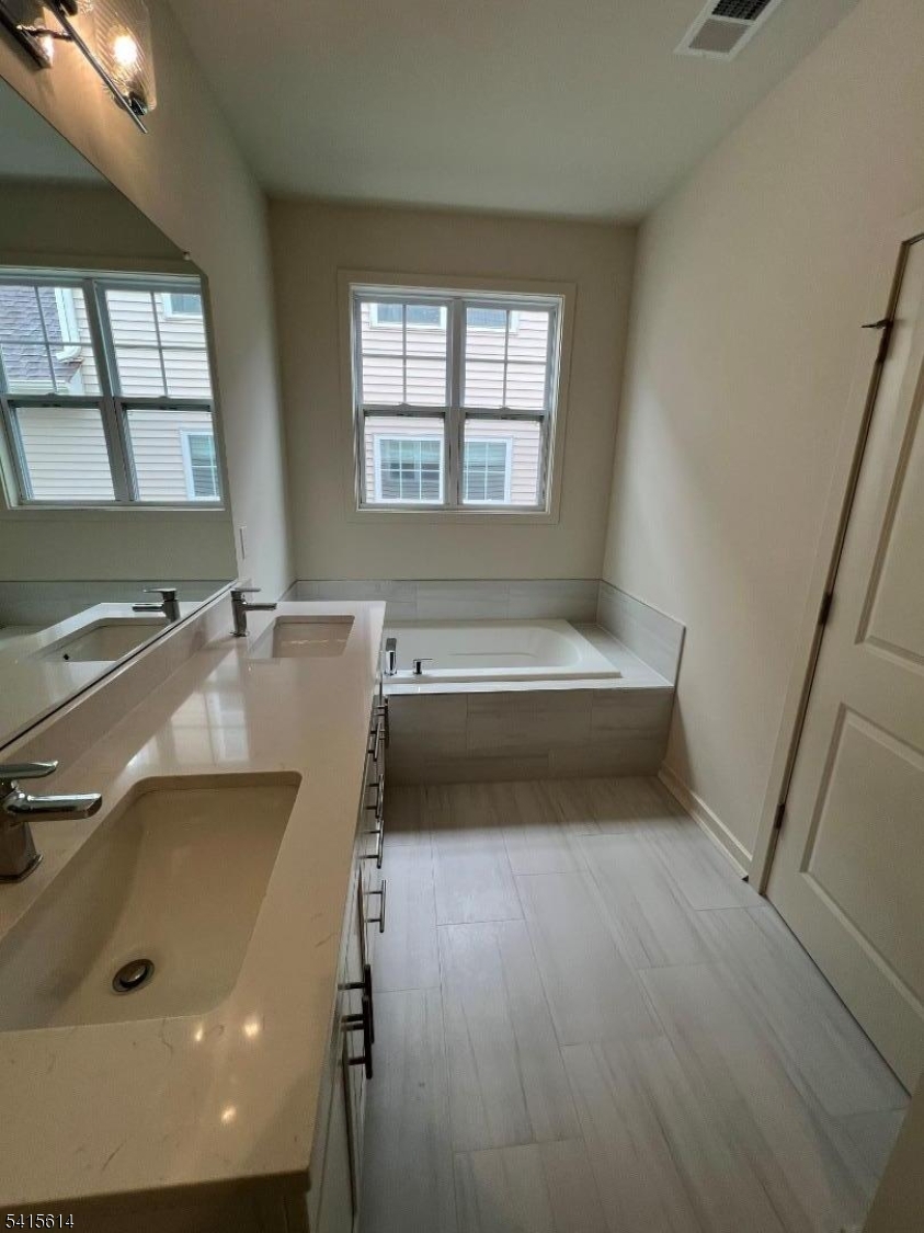 53 Norton Road Hillsborough, NJ 08844 - Photo 12 of 12 a bathroom with a tub a sink and a window