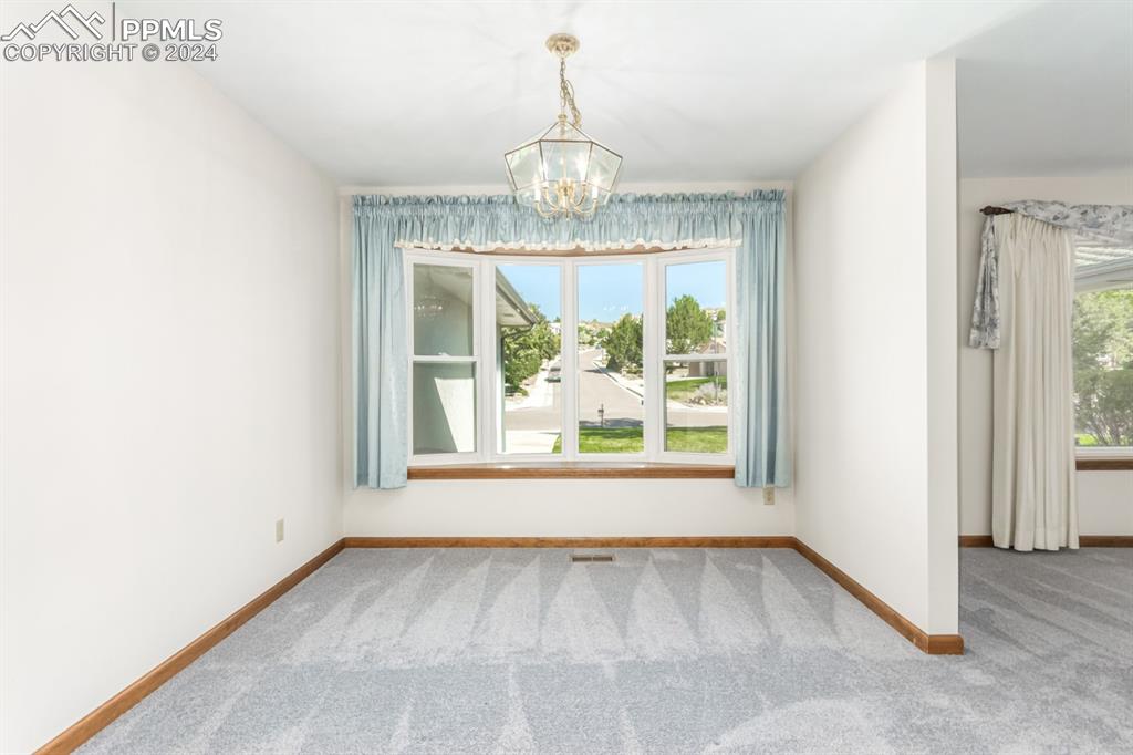 3955 Saddle Rock Road Colorado Springs, CO 80918 - Photo 11 of 45 an empty room with wooden floor and windows