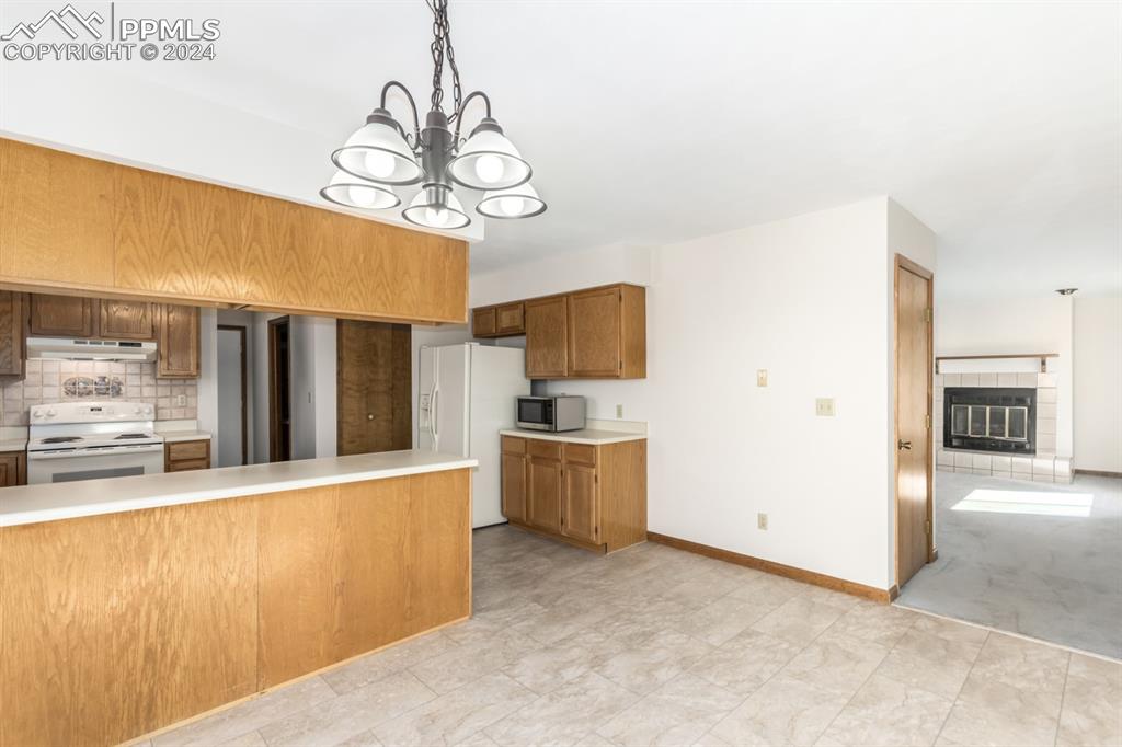 3955 Saddle Rock Road Colorado Springs, CO 80918 - Photo 14 of 45 a view of a kitchen with a sink and dishwasher a refrigerator with wooden floor