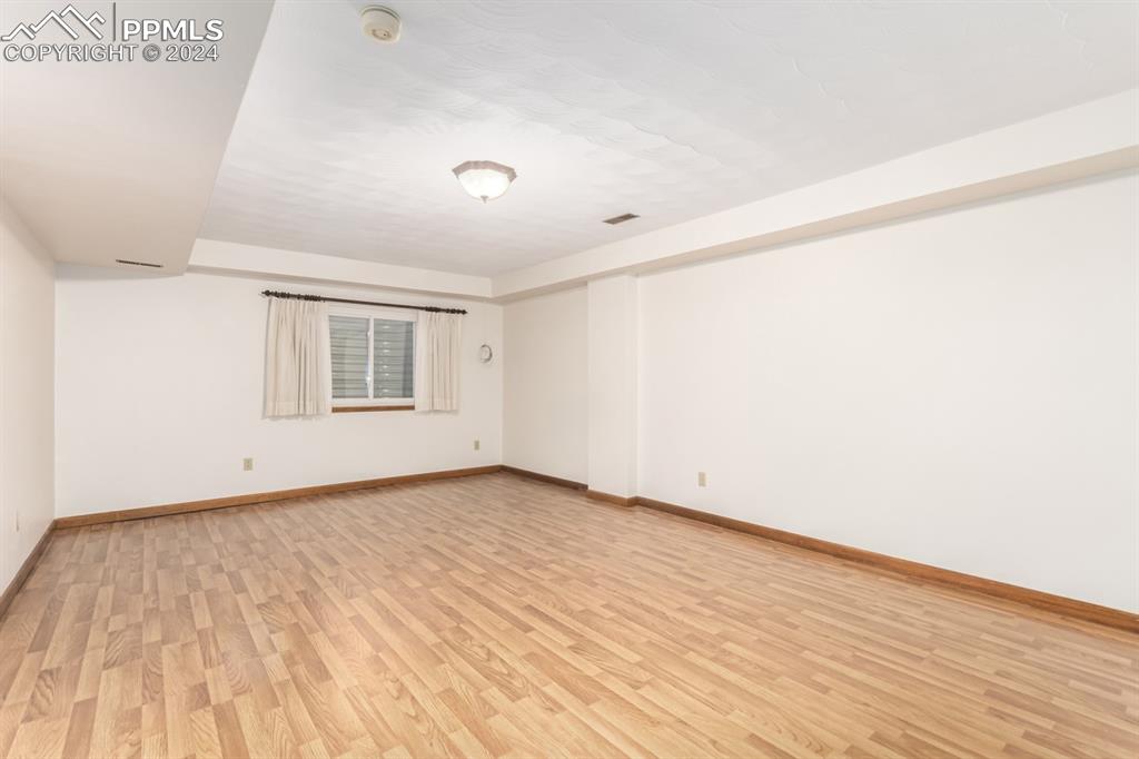 3955 Saddle Rock Road Colorado Springs, CO 80918 - Photo 33 of 45 an empty room with wooden floor and windows