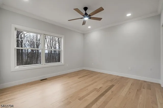 an empty room with windows and ceiling fan