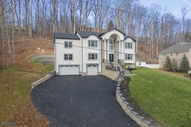 a view of a white house with a big yard and large trees
