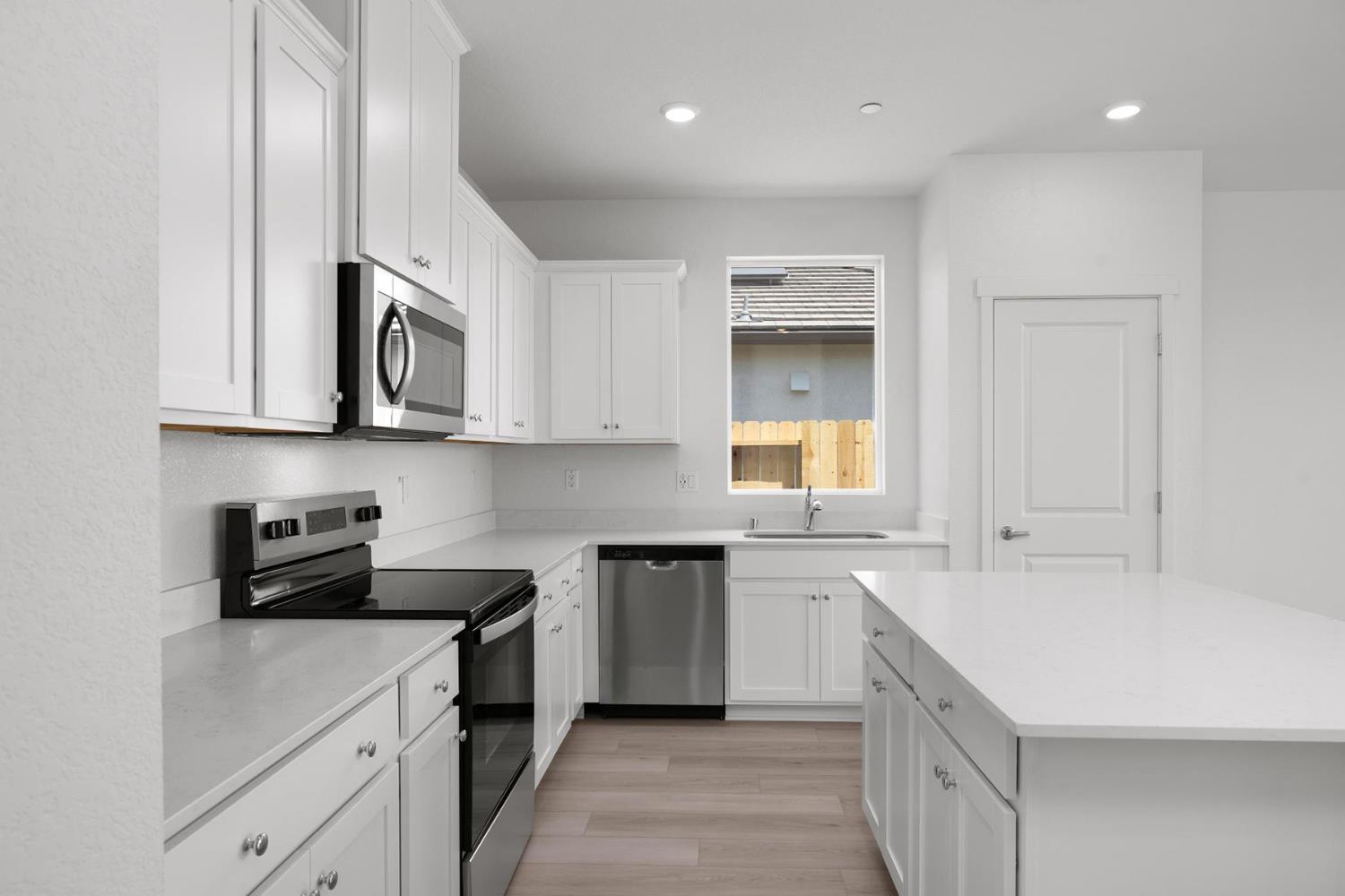 816 Chatham Lane Patterson, CA 95363 - Photo 4 of 15 a kitchen with stainless steel appliances granite countertop a sink and dishwasher a stove top oven with white cabinets