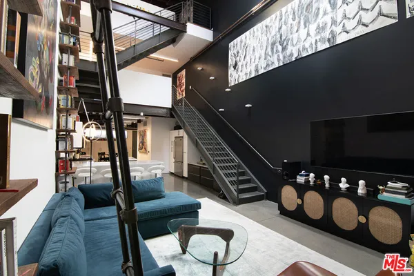 a living room with furniture and wall paintings