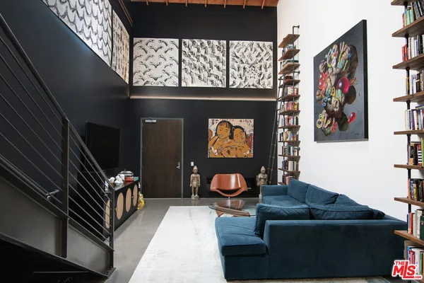 a living room with furniture a bookshelf and a window