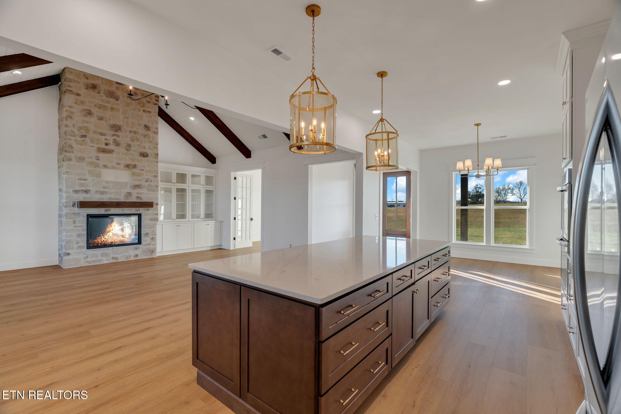 245 Pates Hill Road Mosheim, TN 37818 - Photo 6 of 35 a room with kitchen island a chandelier and wooden floor