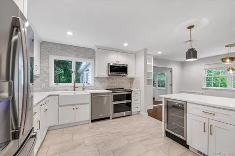 a large kitchen with stainless steel appliances granite countertop a stove a sink and a refrigerator