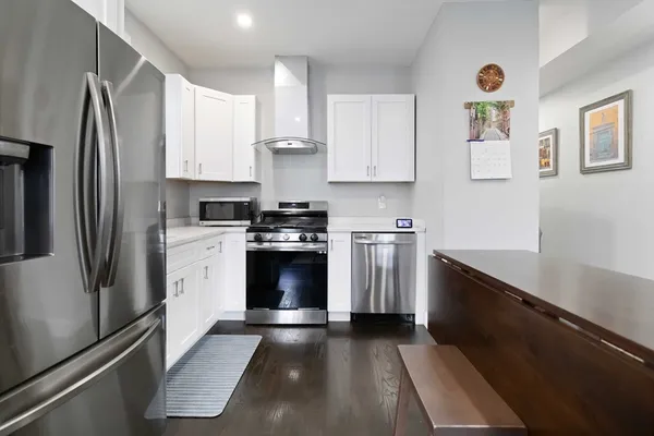 a kitchen with granite countertop a refrigerator stove and sink