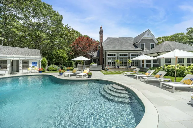 a view of a house with swimming pool and sitting area