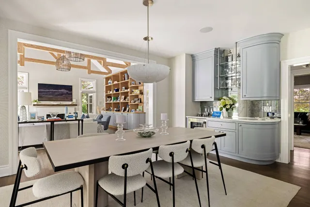 a kitchen with stainless steel appliances a white table chairs and a window
