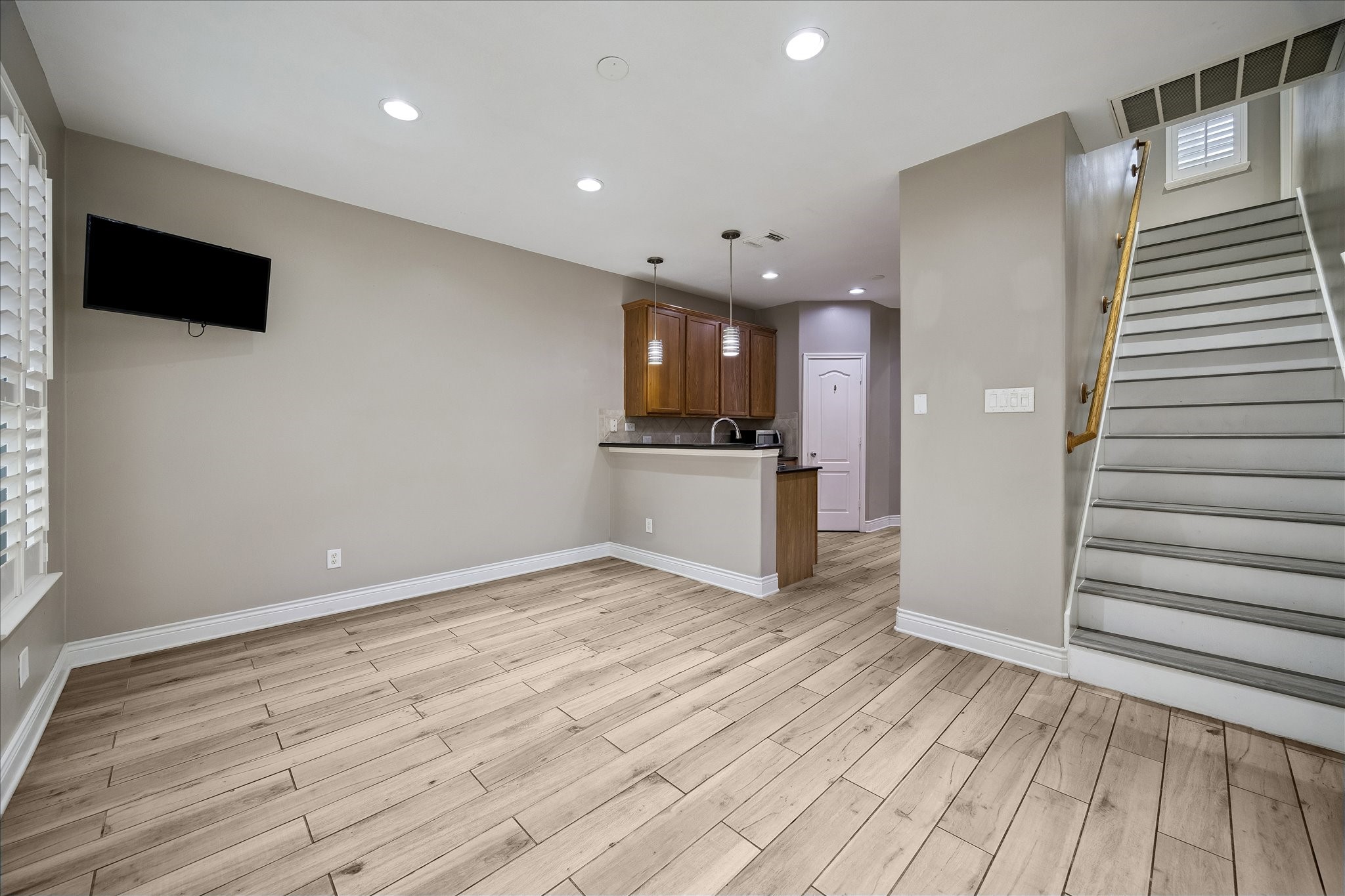 7403 Hollister Ridge Houston, TX 77040 - Photo 6 of 12 an empty room with wooden floor and kitchen view