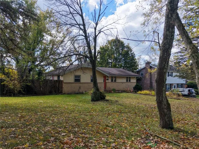 a house that has a tree in front of a house