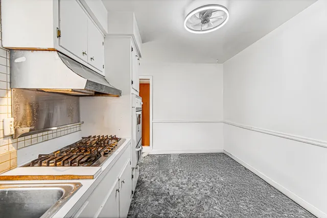 a kitchen with a refrigerator and a stove top oven