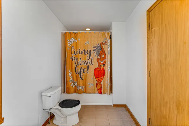 a bathroom with a toilet and a shower curtain