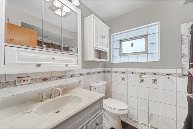 a bathroom with a sink toilet vanity and mirror