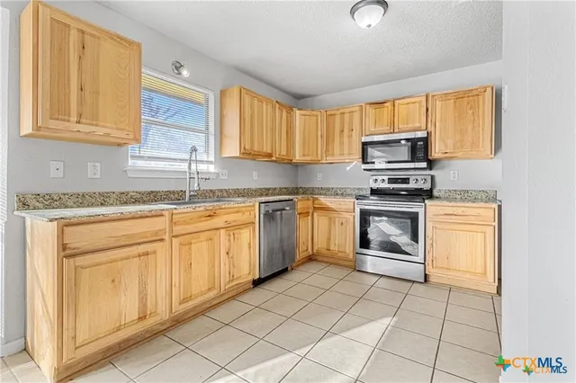 a kitchen with a stove sink and cabinets