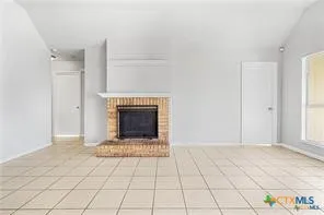 a view of an empty room with window and fire place