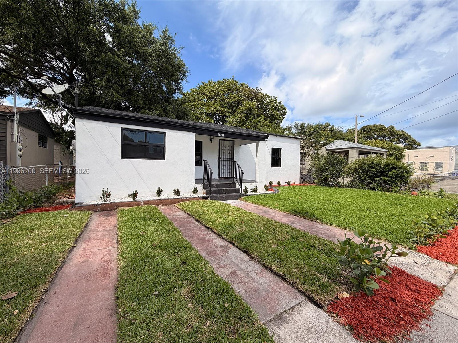 1261 Northwest 45th Street Miami, FL 33142 - Photo 2 of 95 a front view of a house with garden