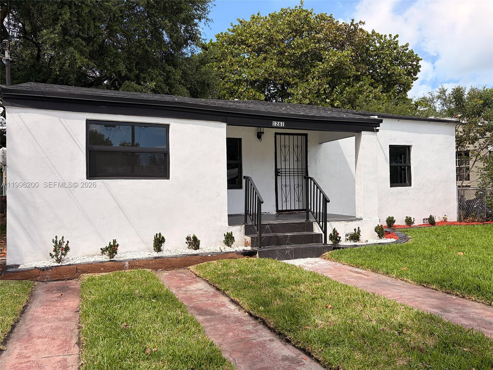 1261 Northwest 45th Street Miami, FL 33142 - Photo 23 of 95 a front view of a house with a yard