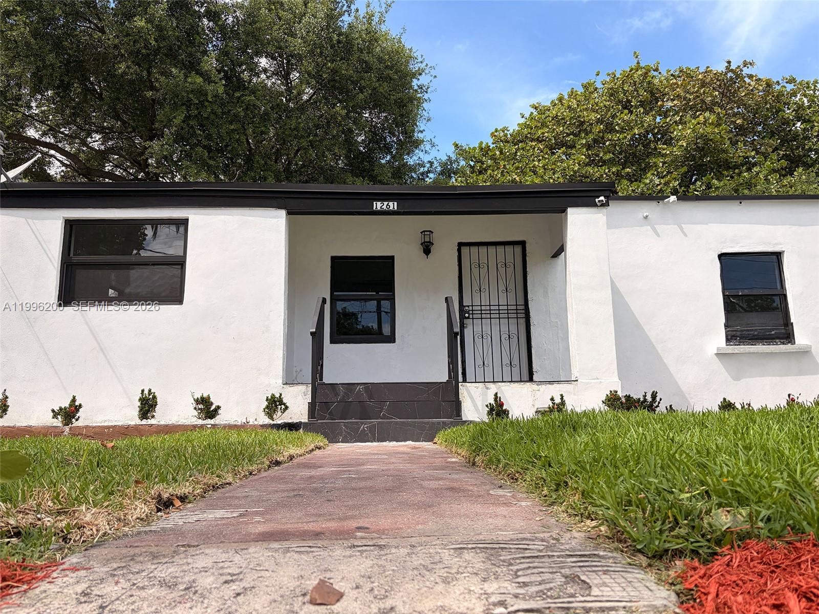 1261 Northwest 45th Street Miami, FL 33142 - Photo 25 of 95 a front view of a house with a yard