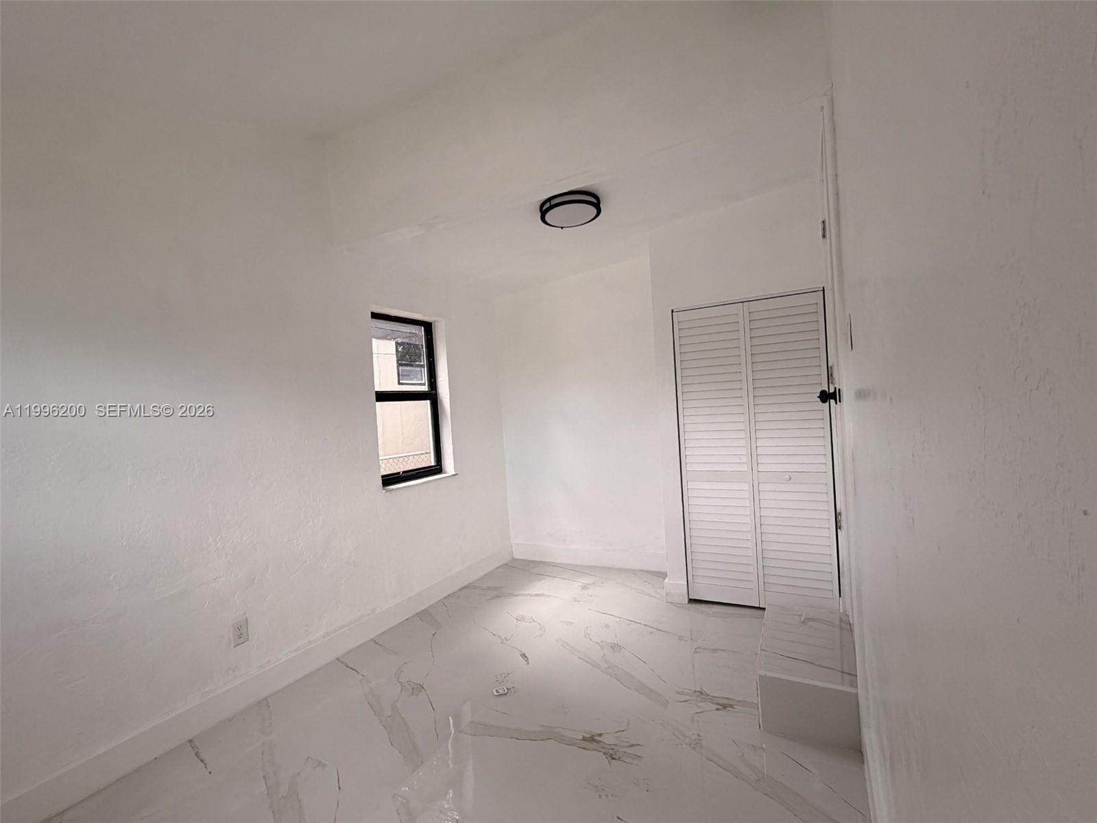 1261 Northwest 45th Street Miami, FL 33142 - Photo 31 of 95 an empty room with windows and closet