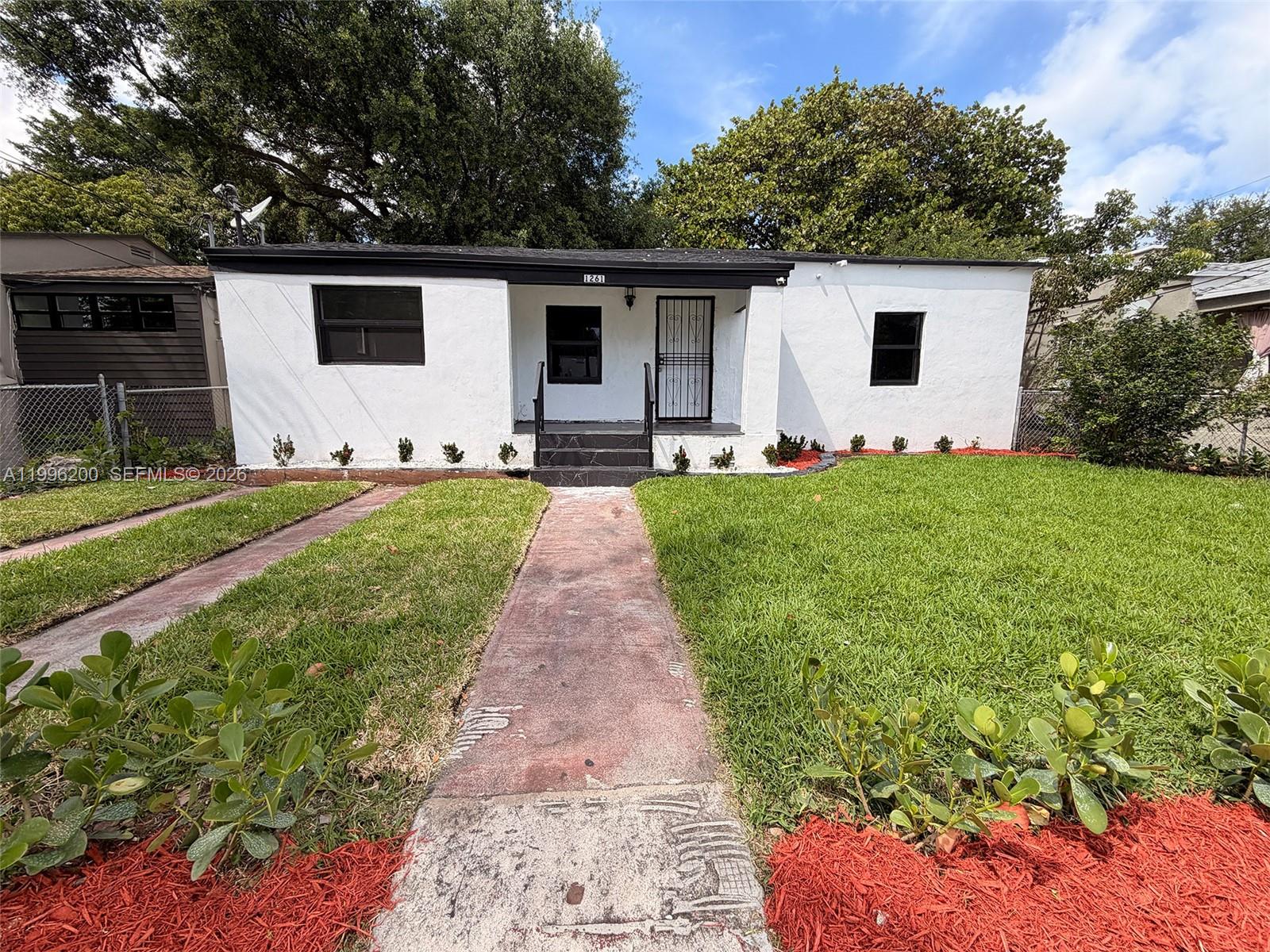 1261 Northwest 45th Street Miami, FL 33142 - Photo 4 of 95 a front view of a house with a yard