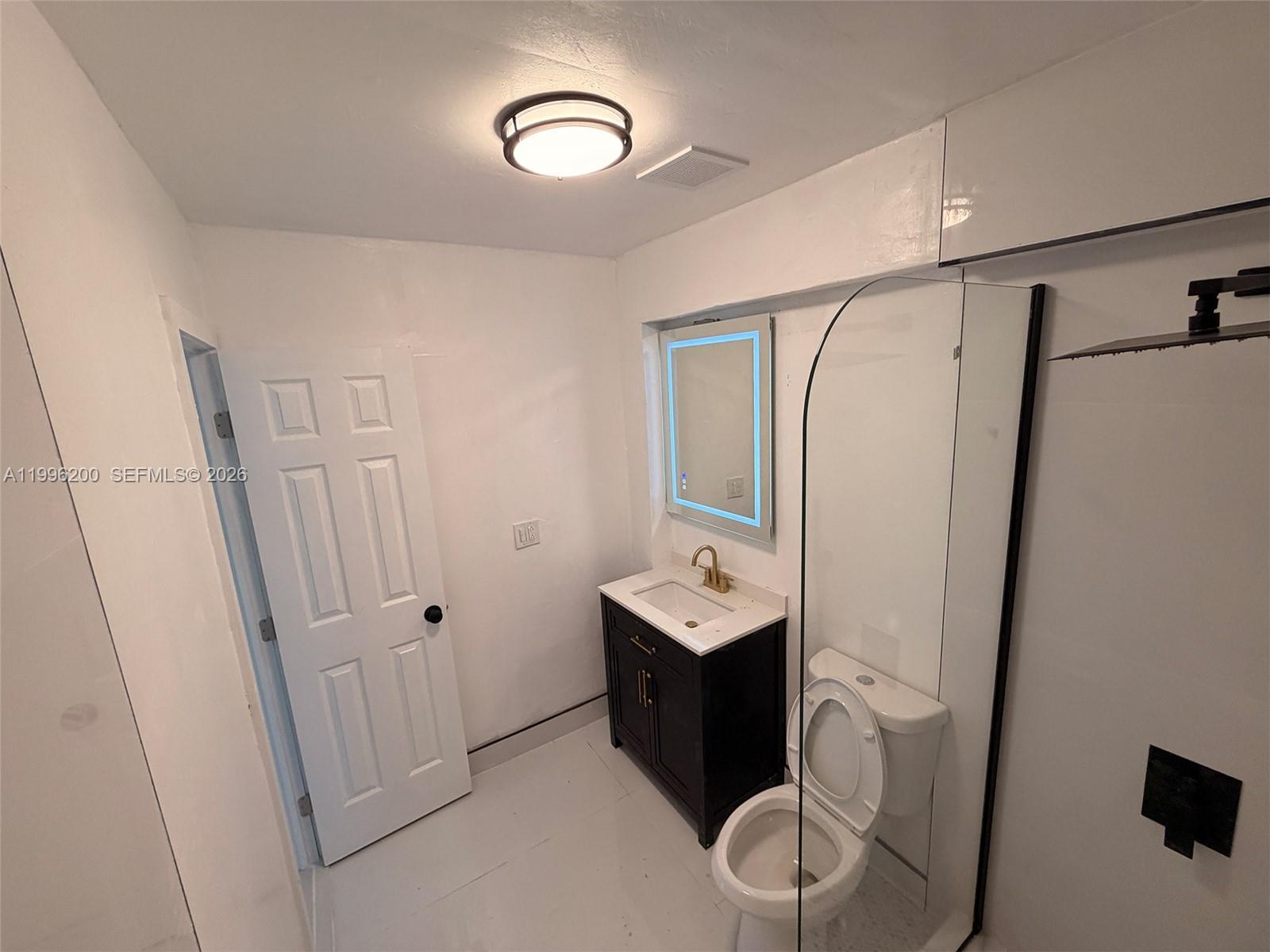 1261 Northwest 45th Street Miami, FL 33142 - Photo 46 of 95 a bathroom with a sink a toilet a mirror and shower