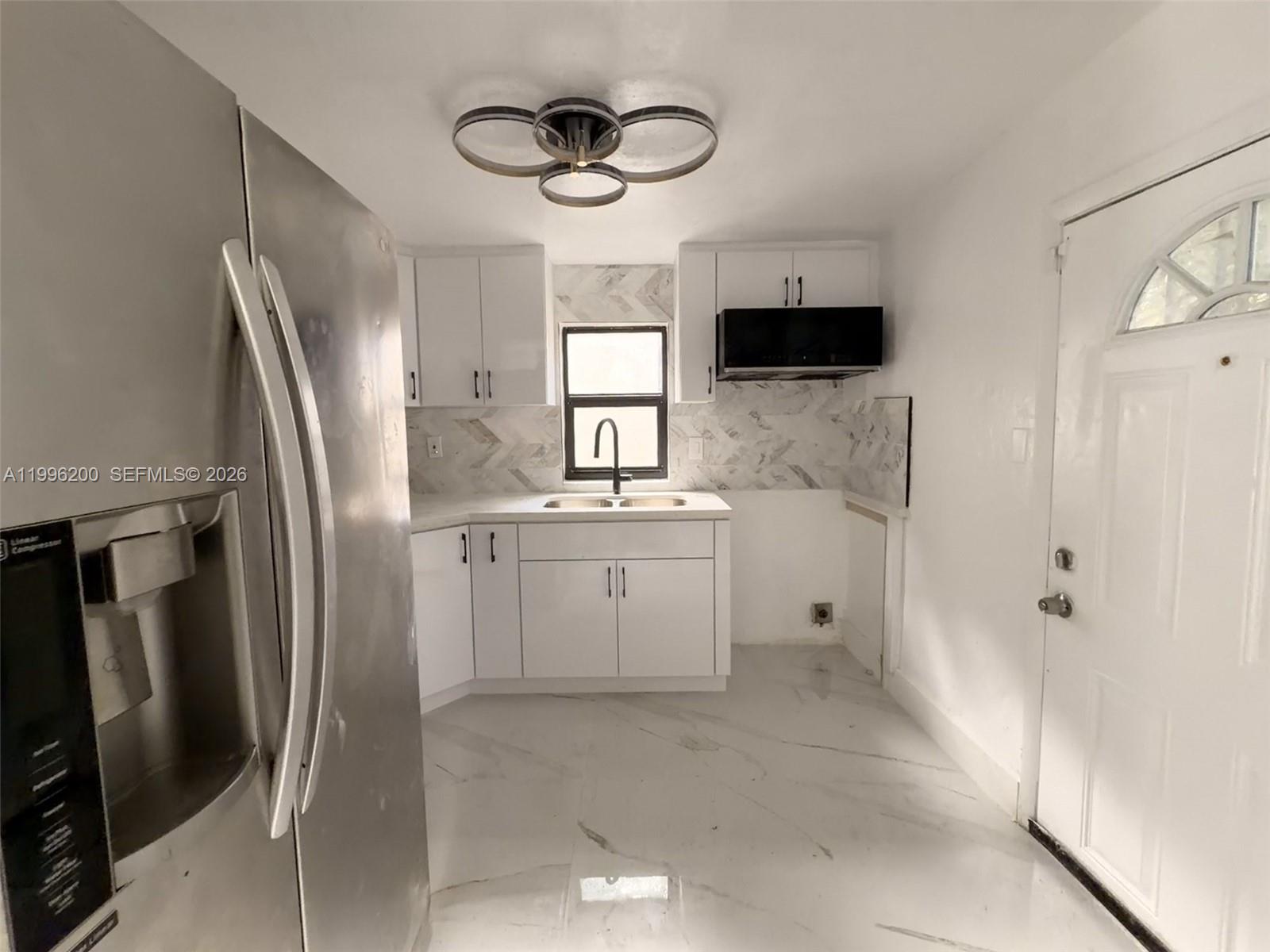 1261 Northwest 45th Street Miami, FL 33142 - Photo 49 of 95 a kitchen with white cabinets and stainless steel appliances
