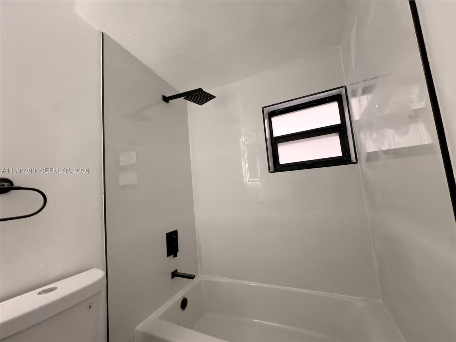 1261 Northwest 45th Street Miami, FL 33142 - Photo 61 of 95 a bathroom with a bathtub shower and toilet