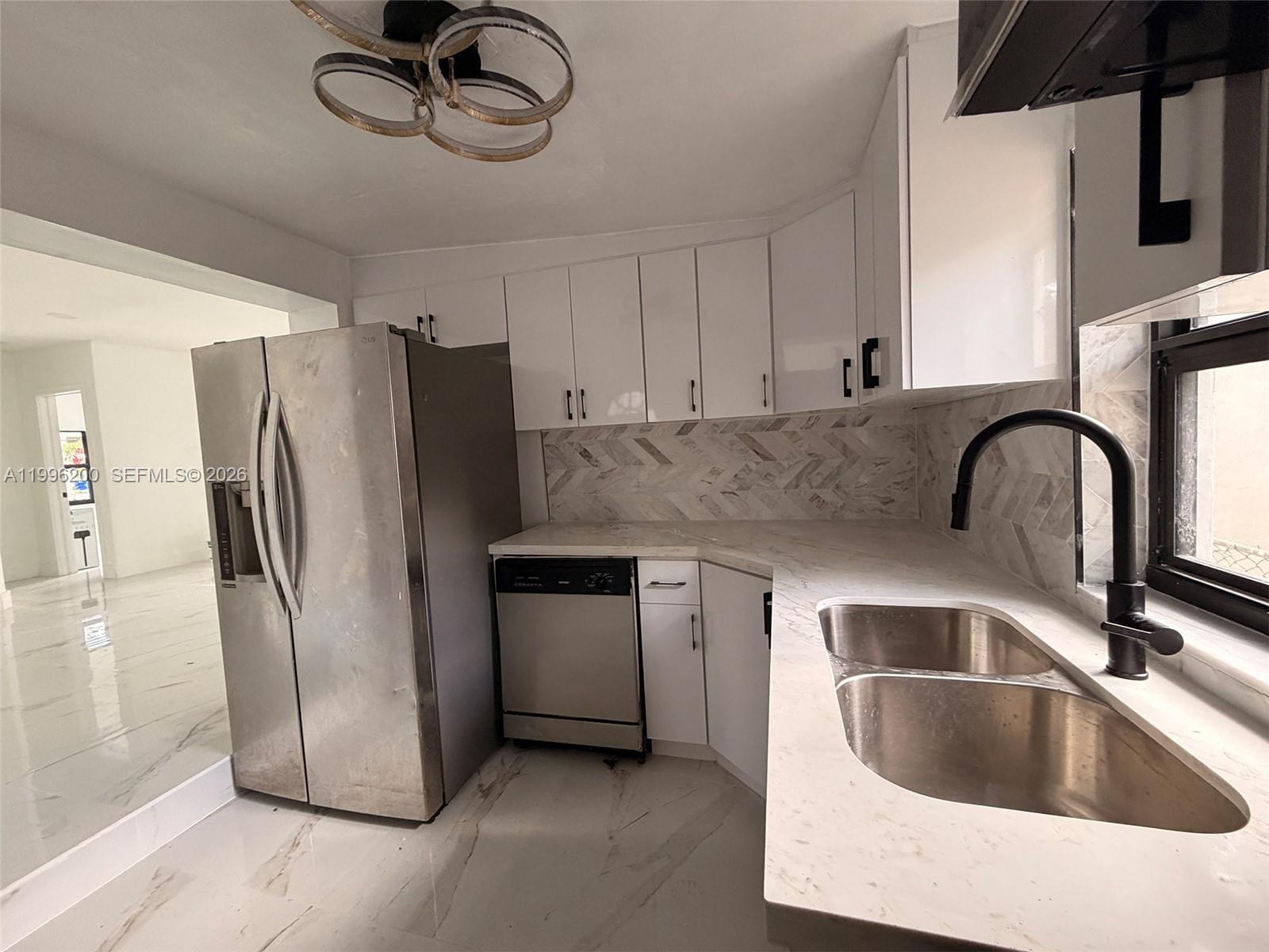 1261 Northwest 45th Street Miami, FL 33142 - Photo 63 of 95 a kitchen with stainless steel appliances granite countertop a refrigerator a sink a stove with cabinets