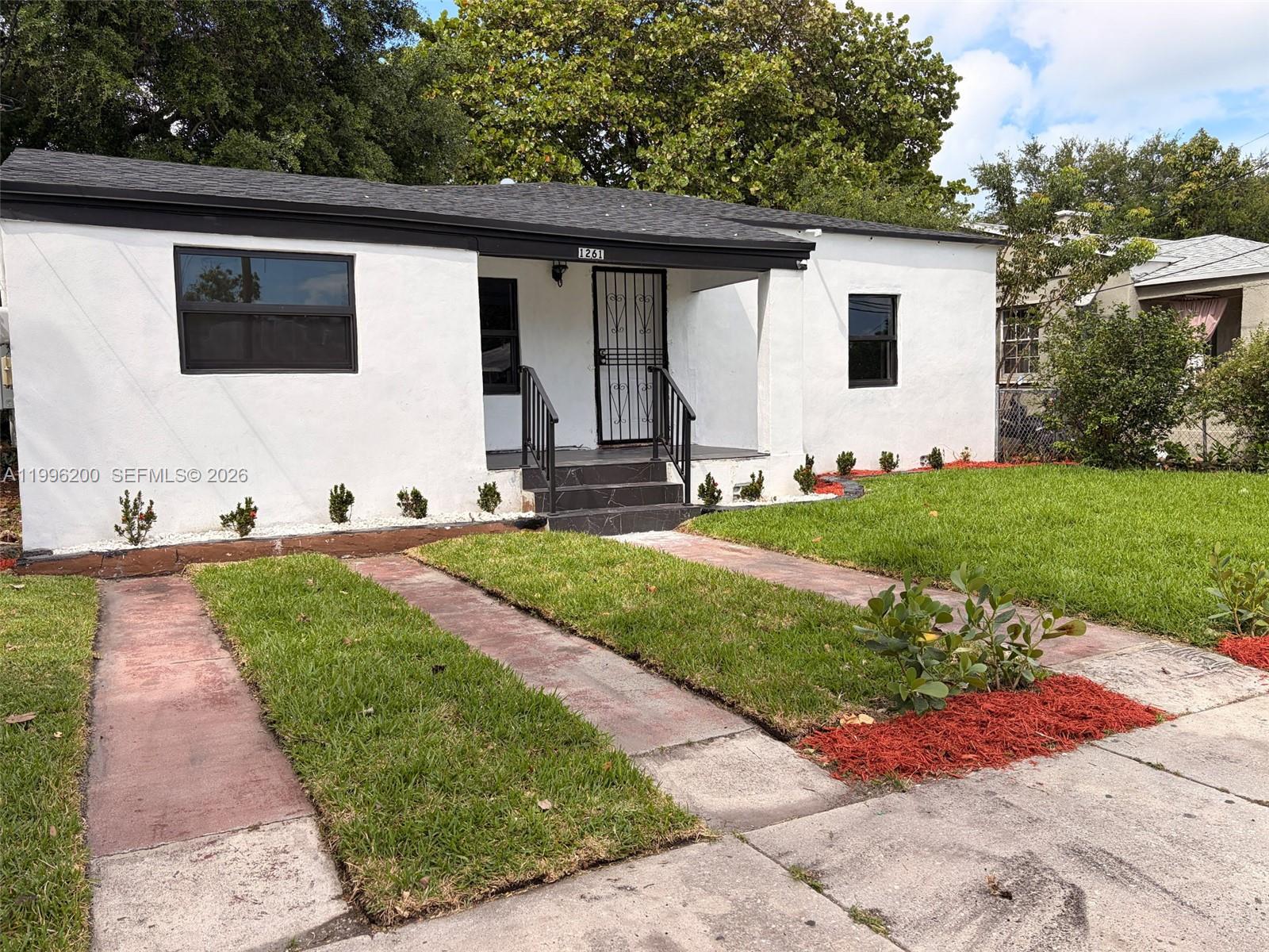 1261 Northwest 45th Street Miami, FL 33142 - Photo 10 of 95 a front view of a house with a yard