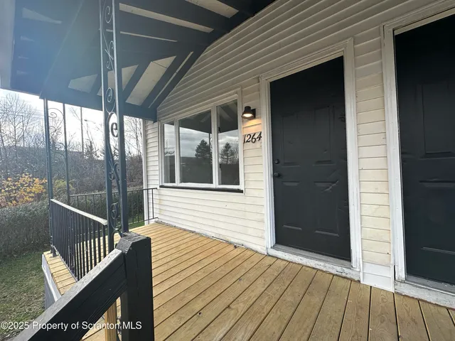 a view of deck with wooden floor and door