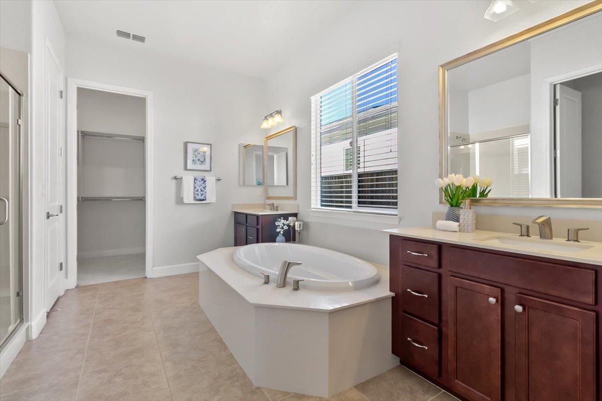 7842 Cinnamon Way Gilroy, CA 95020 - Photo 18 of 51 a spacious bathroom with a tub sink and mirror