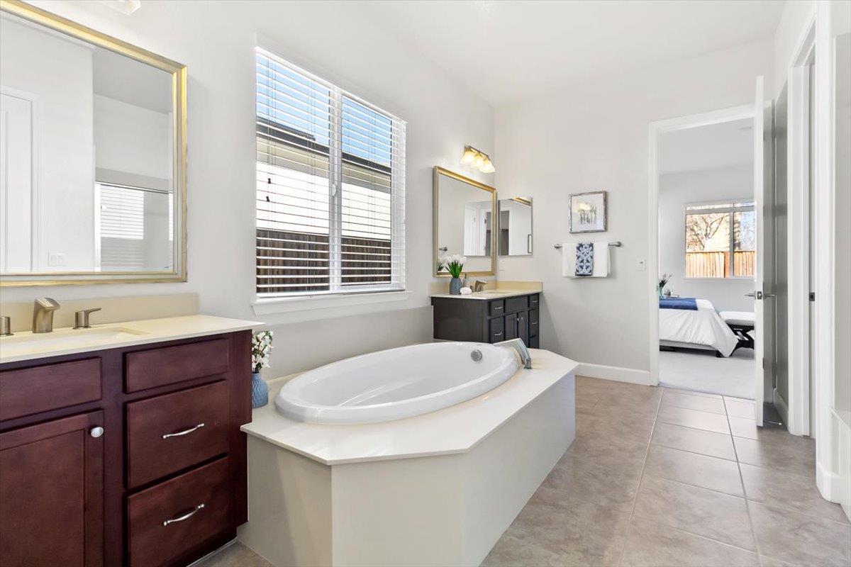 7842 Cinnamon Way Gilroy, CA 95020 - Photo 19 of 51 a spacious bathroom with a tub sink and mirror
