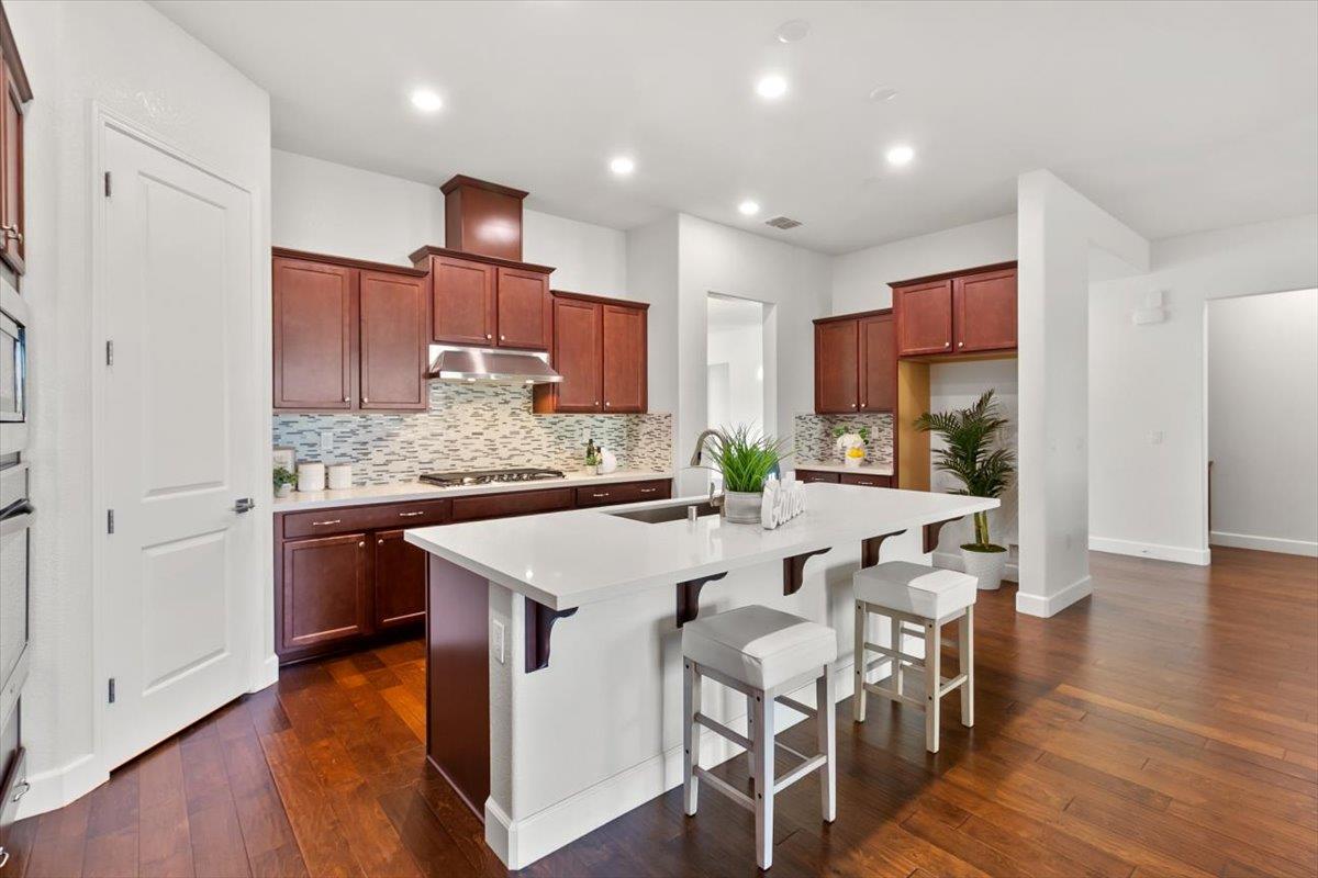 7842 Cinnamon Way Gilroy, CA 95020 - Photo 25 of 51 a kitchen with stainless steel appliances granite countertop a sink a stove a refrigerator and island with wooden floor