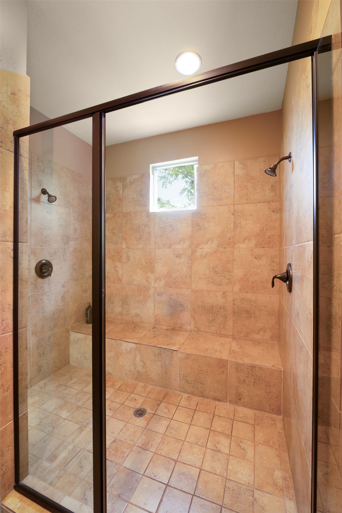 2302 East 9th Street Austin, TX 78702 - Photo 19 of 31 A spacious, naturally illuminated shower with built-in seating and dual showerheads.