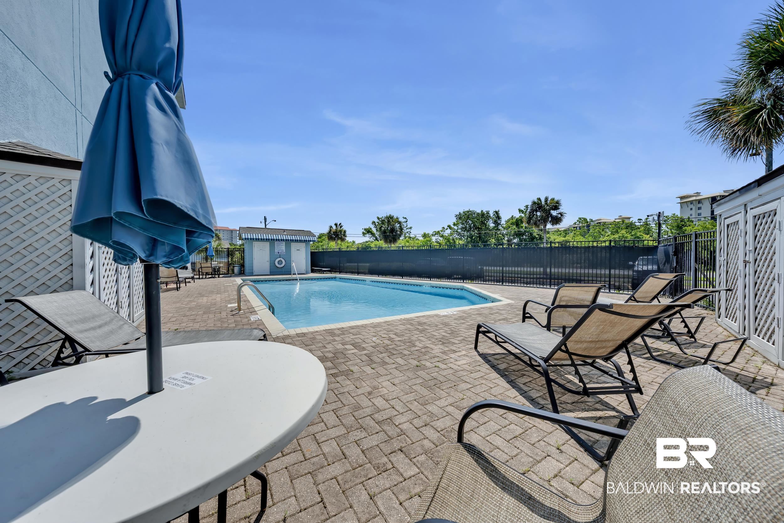 14100 River Road, Unit 211 Pensacola, FL 32507 - Photo 7 of 56 Outdoor swimming pool surrounded by a brick paver deck
