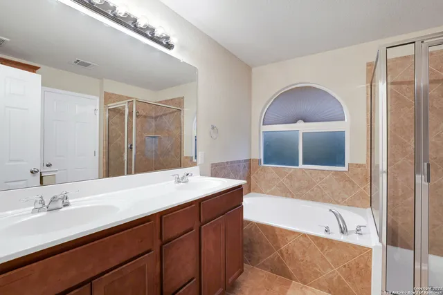 a bathroom with a tub a sink and mirror