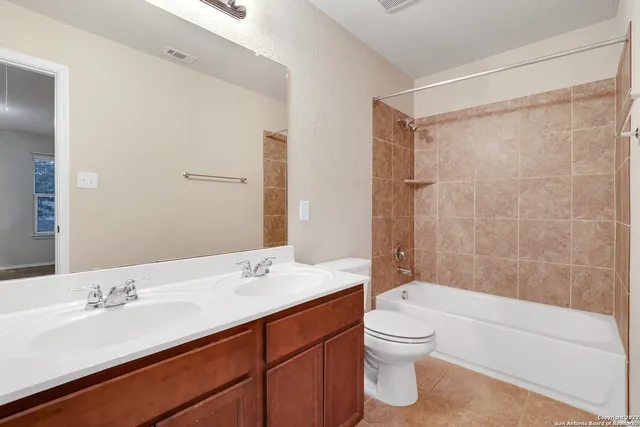 a bathroom with a granite countertop sink toilet a large mirror a bathtub and shower