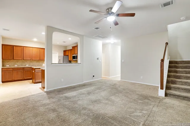 wooden floor in an empty room with a cabinet and a ceiling fan