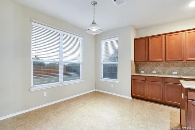 a bathroom with a granite countertop sink and dishwasher next to a window