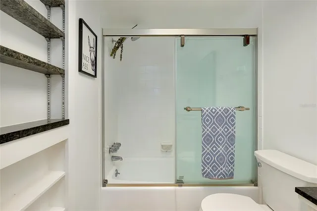 a bedroom with a bed and a lamp on dresser